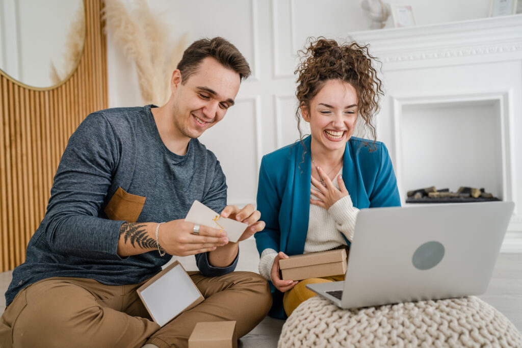 couple woman and man open presents and read card while on video call